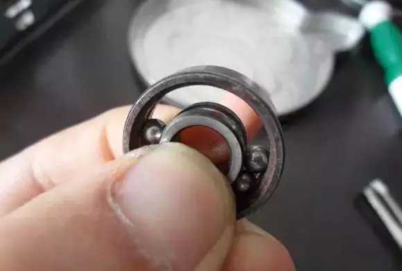 用手將軸承拿起，需要注意要向有滾珠的方向頂住